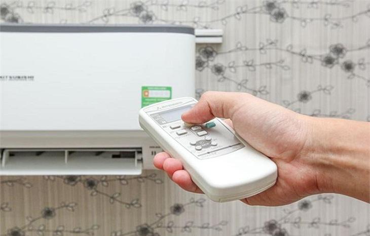 Người dùng đang sử dụng remote để kiểm tra mã lỗi điều hòa Daikin, hiển thị trên màn hình điều khiển.
