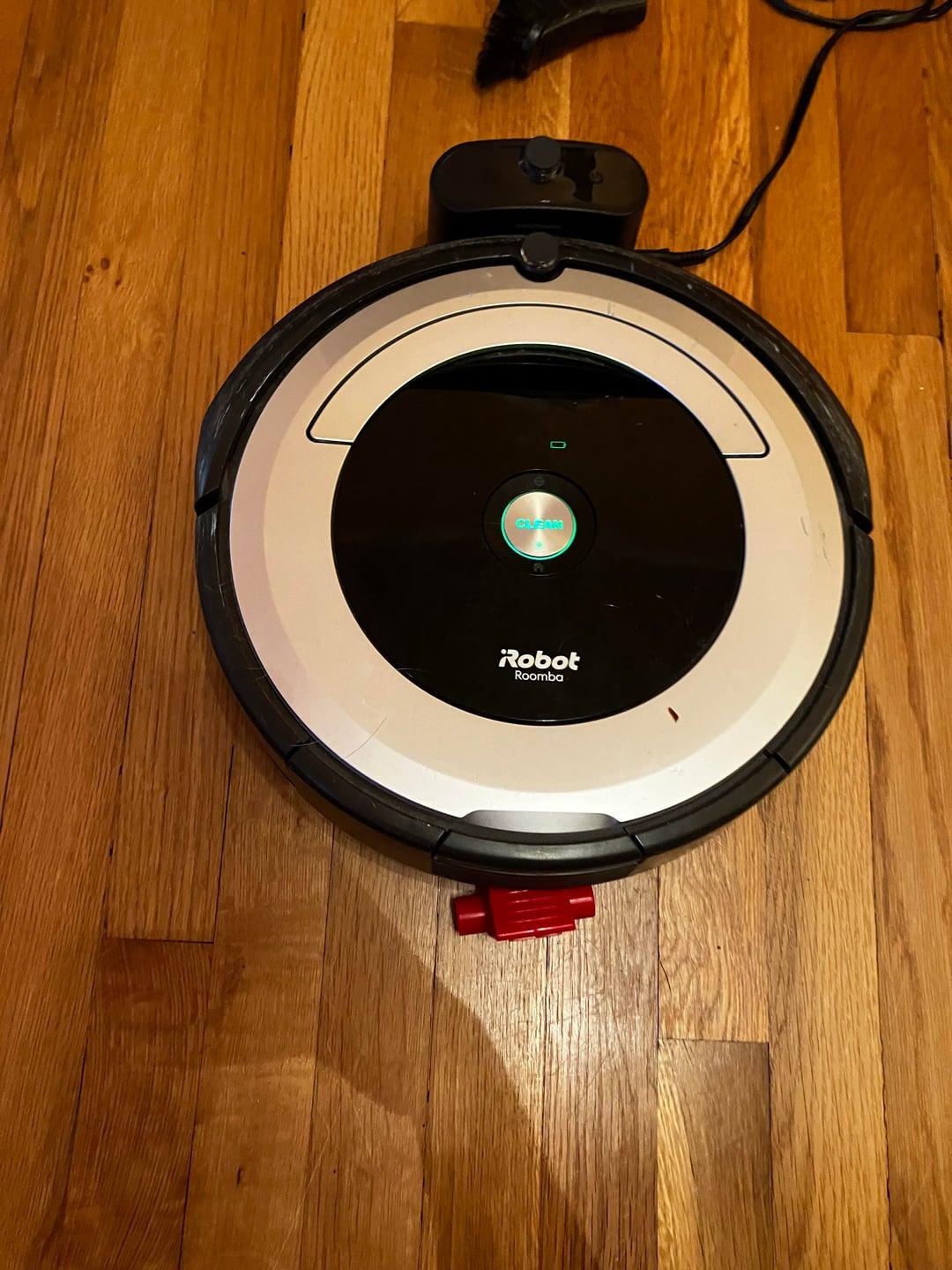 Robot hút bụi không sạc được pin hoặc không lên nguồn, người dùng đang kiểm tra các điểm tiếp xúc sạc.