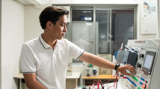 Một kỹ sư đang kiểm tra hệ thống cơ điện trong phòng máy của tòa nhà, minh họa vai trò quan trọng của cơ điện là gì